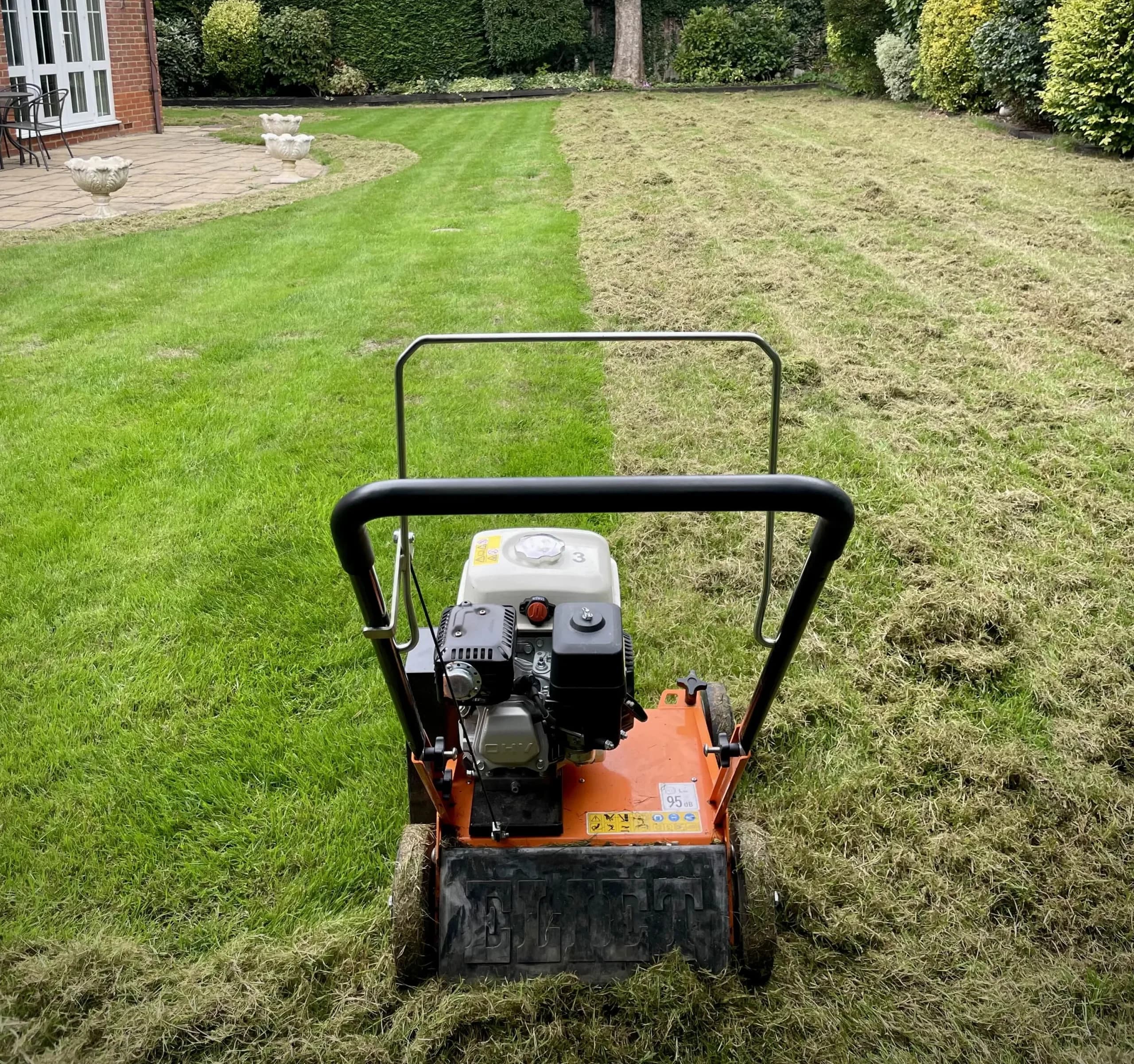 Image of scarifier on a lawn in the UK that has been half scarified